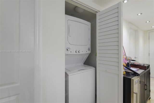 clothes washing area featuring stacked washer / dryer