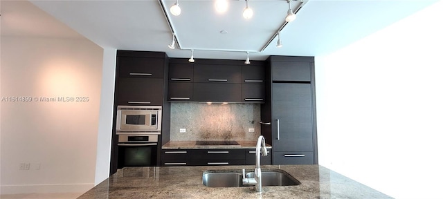 kitchen with rail lighting, modern cabinets, stainless steel appliances, a sink, and backsplash