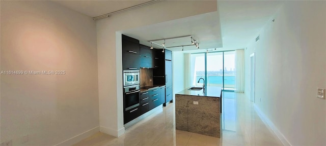 kitchen featuring light tile patterned flooring, modern cabinets, stainless steel appliances, and tasteful backsplash