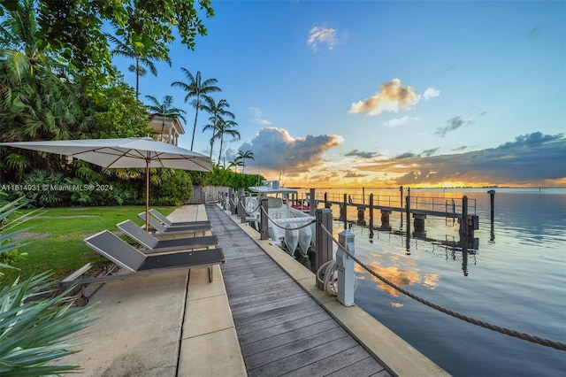 view of dock featuring a water view and a lawn