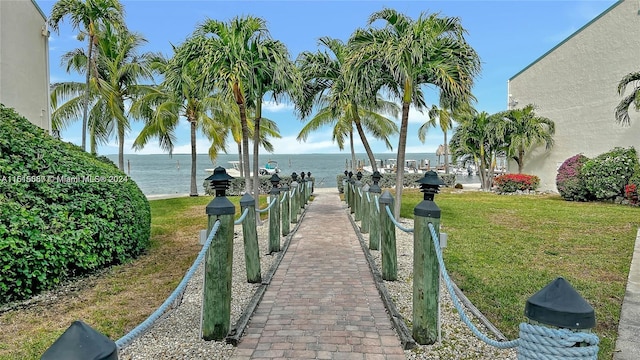 view of property's community with a yard and a water view