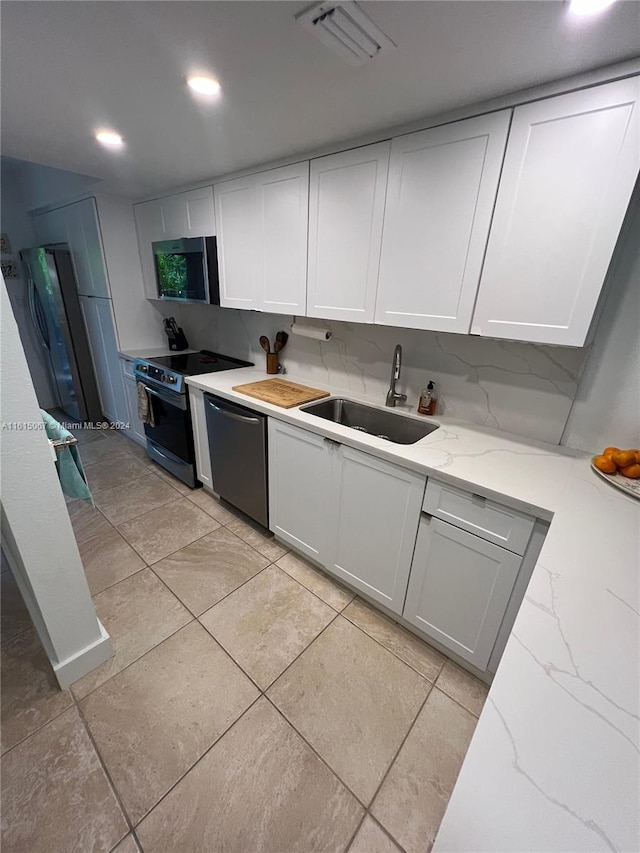 kitchen with backsplash, white cabinetry, sink, and appliances with stainless steel finishes