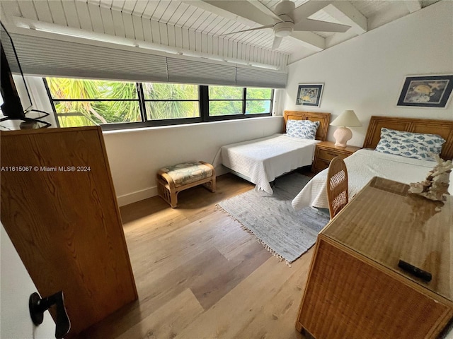 bedroom featuring beam ceiling, hardwood / wood-style flooring, ceiling fan, and wooden ceiling