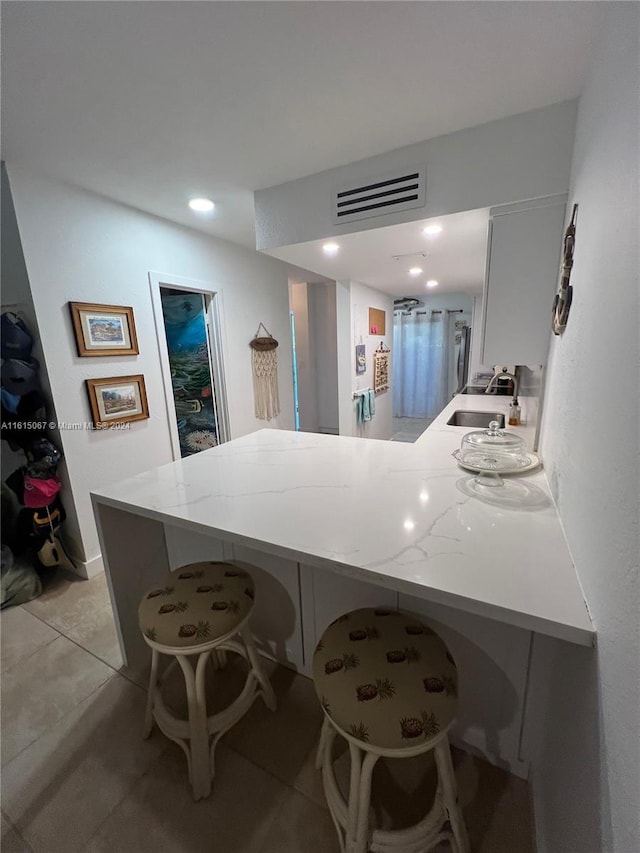 kitchen featuring light stone countertops, tasteful backsplash, stainless steel appliances, sink, and white cabinetry