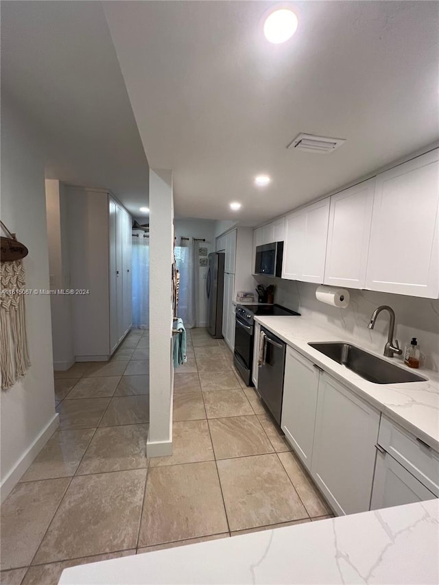 kitchen with white cabinets, sink, appliances with stainless steel finishes, and tasteful backsplash