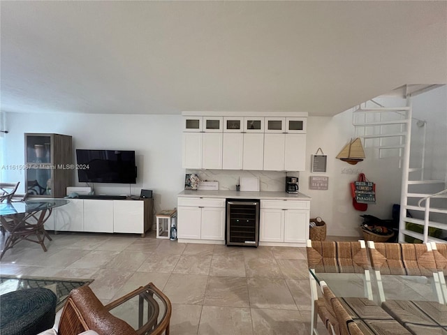 bar featuring tasteful backsplash, wine cooler, white cabinetry, and light tile patterned flooring