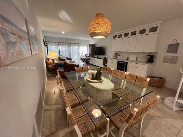 kitchen with light stone countertops, pendant lighting, white cabinets, and beverage cooler