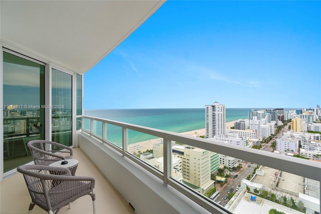 balcony featuring a water view and a view of the beach