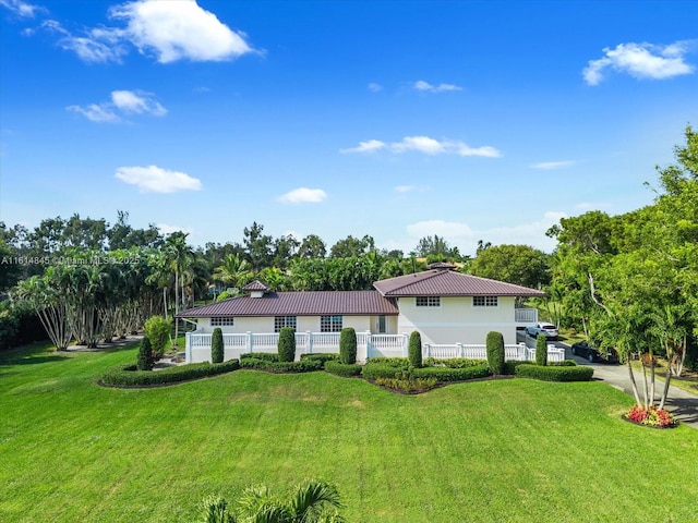 rear view of house featuring a lawn