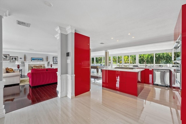 kitchen featuring ornate columns, a kitchen island, crown molding, and stainless steel dishwasher