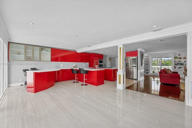 kitchen featuring stainless steel fridge with ice dispenser, crown molding, a breakfast bar area, and a center island