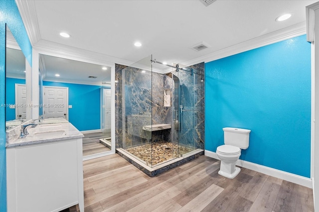 bathroom featuring hardwood / wood-style floors, toilet, vanity, and crown molding