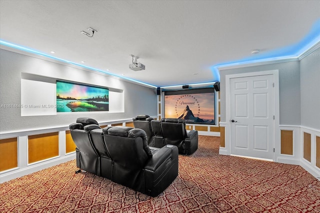 carpeted home theater room featuring crown molding