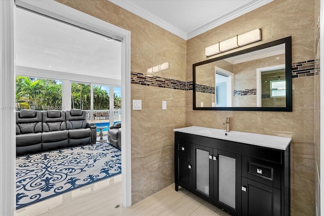 bathroom with ornamental molding, tile walls, tile patterned floors, and vanity