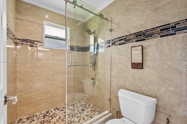 bathroom featuring toilet, a shower with door, and crown molding