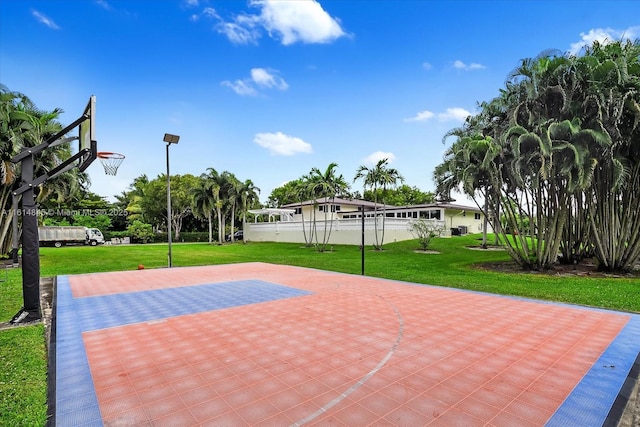 view of basketball court with a yard