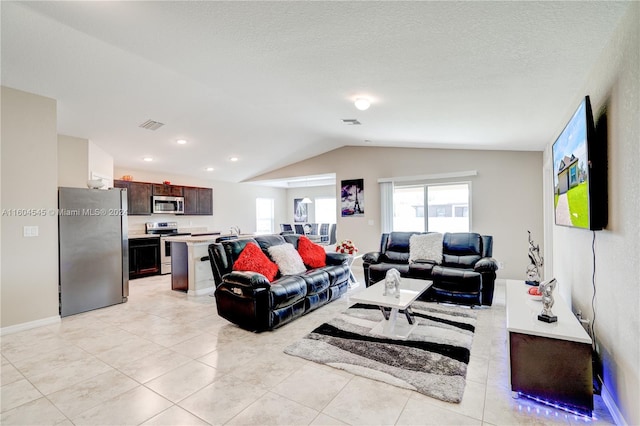 tiled living room with a textured ceiling and lofted ceiling