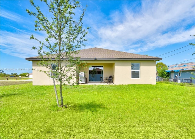 rear view of property with a yard