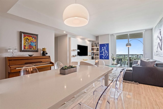 kitchen featuring expansive windows, hanging light fixtures, and light hardwood / wood-style floors