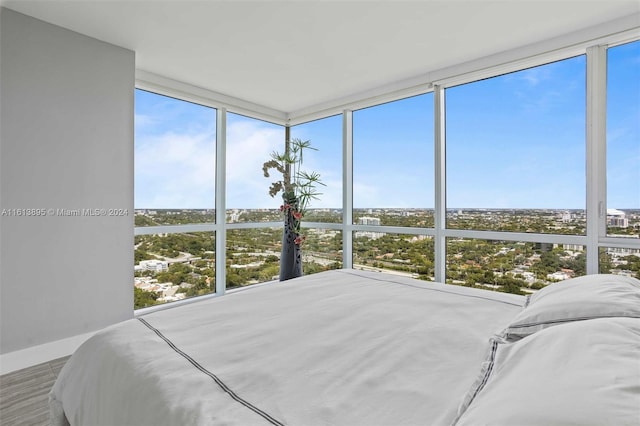 bedroom featuring multiple windows, wood-type flooring, and expansive windows