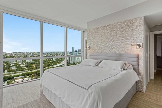 bedroom featuring floor to ceiling windows and light wood-type flooring