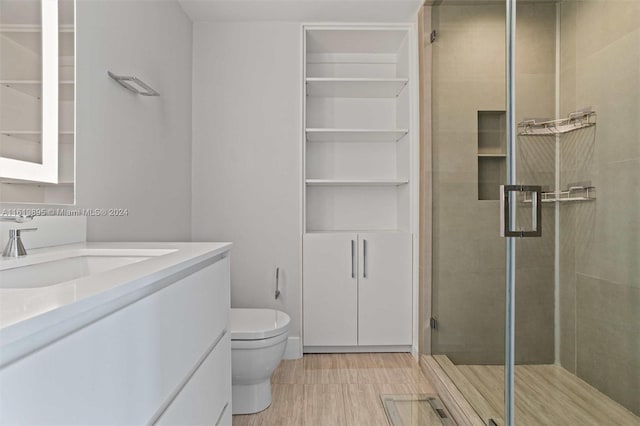 bathroom with vanity, toilet, and a shower with shower door