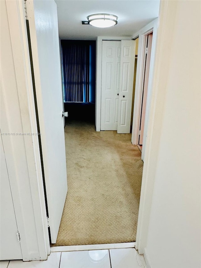 hallway featuring light colored carpet