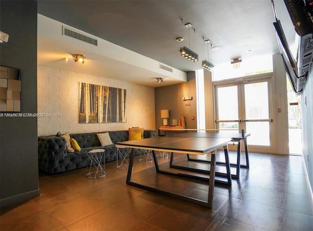 recreation room featuring tile flooring, french doors, and rail lighting