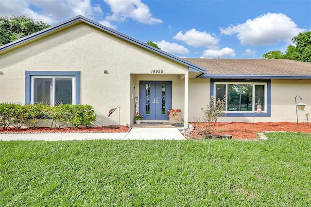 ranch-style home with a front lawn and french doors