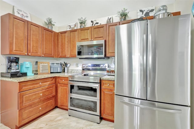 kitchen with light stone countertops and appliances with stainless steel finishes