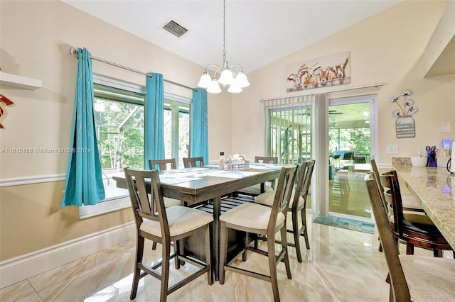 dining area featuring a notable chandelier and lofted ceiling