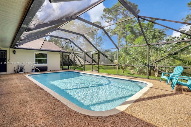 view of pool featuring glass enclosure and a patio area