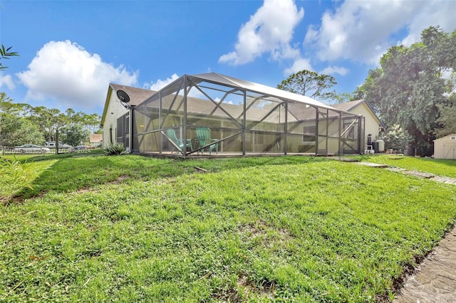 rear view of property featuring glass enclosure and a lawn