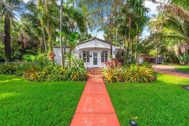 view of front facade with a front yard and french doors