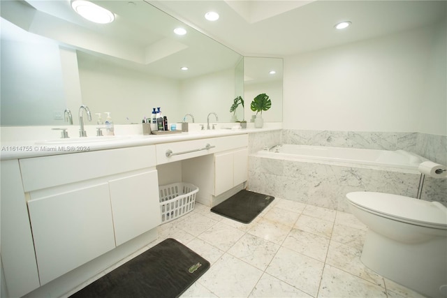 bathroom featuring tiled bath, toilet, vanity, and a tray ceiling