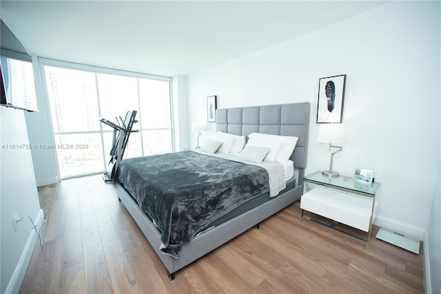 bedroom with wood-type flooring and floor to ceiling windows