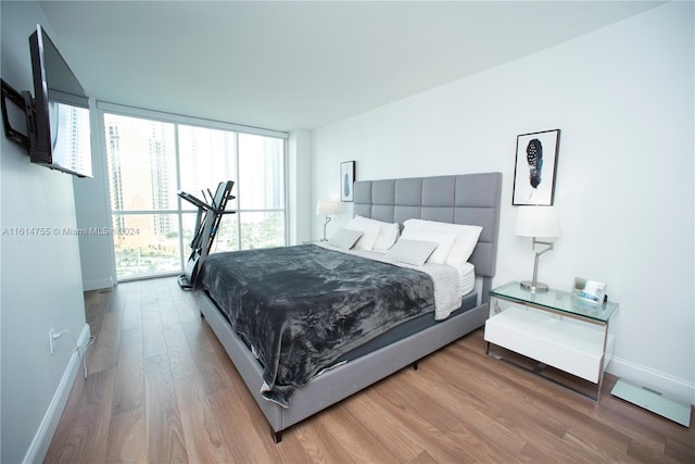 bedroom featuring a wall of windows and wood-type flooring