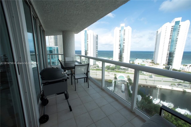 balcony with a water view and a grill