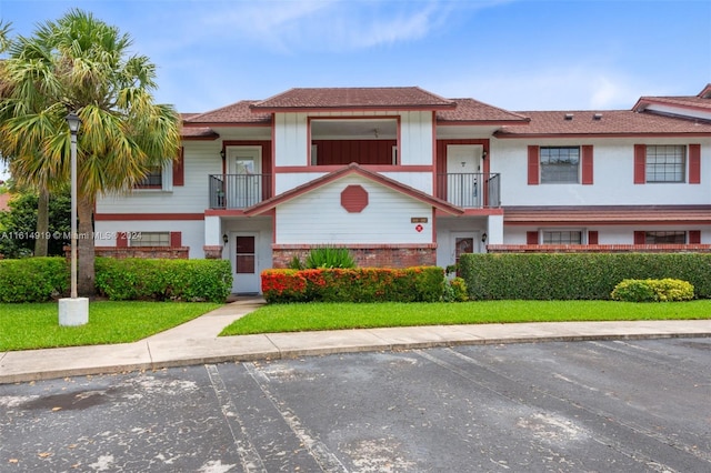 view of front of home featuring a front yard and a balcony