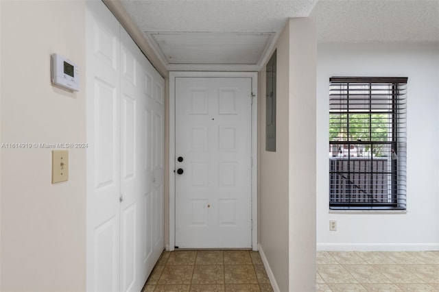 doorway to outside with a textured ceiling