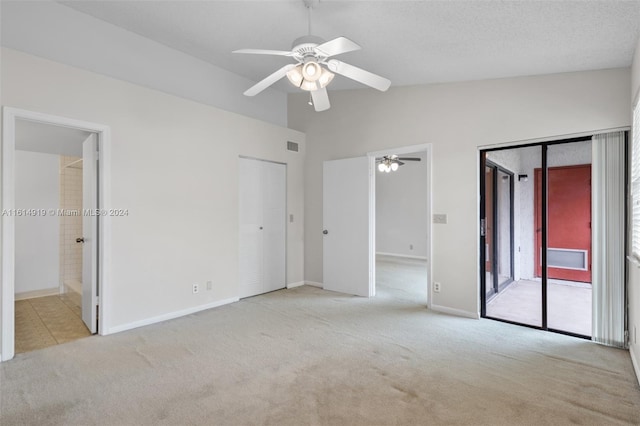 interior space featuring ceiling fan, access to outside, vaulted ceiling, and light colored carpet