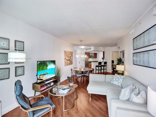 living room with hardwood / wood-style flooring and an inviting chandelier