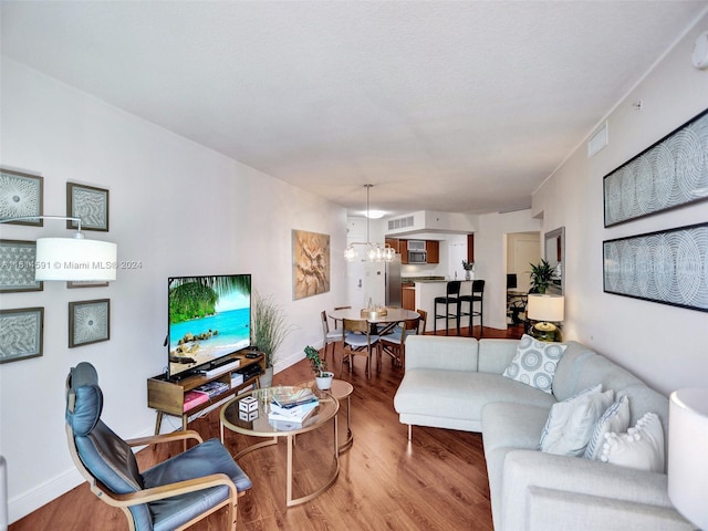 living room with light hardwood / wood-style floors and a chandelier