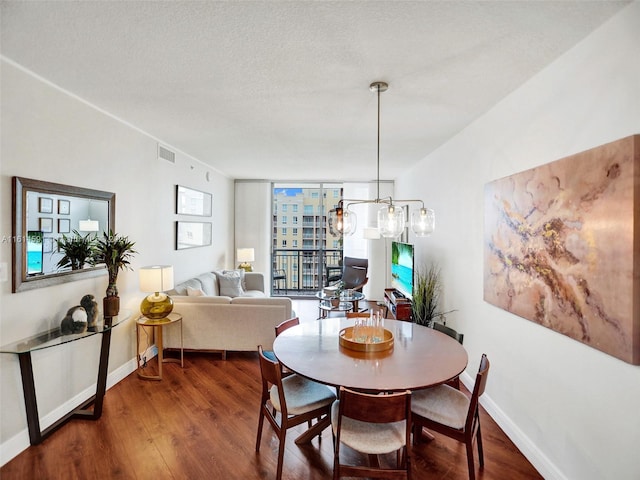 dining room featuring a textured ceiling, hardwood / wood-style floors, expansive windows, and a chandelier