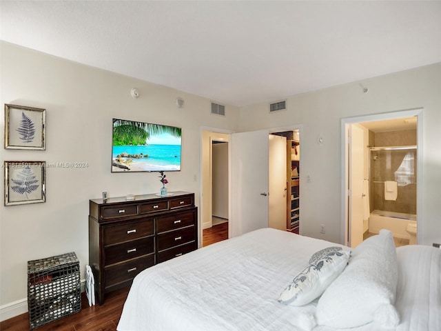 bedroom with dark hardwood / wood-style flooring and connected bathroom