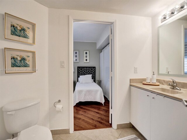 bathroom with tile flooring, vanity, and toilet