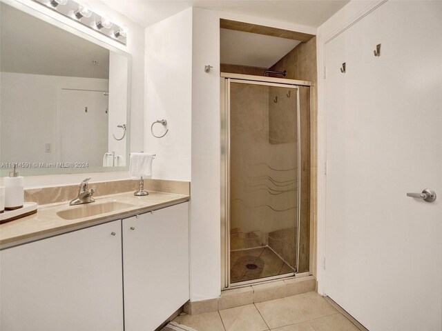 bathroom with a shower with door, tile flooring, and large vanity