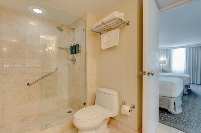 bathroom with tiled shower, tile patterned flooring, and toilet