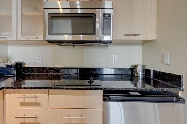 kitchen featuring dark stone counters and appliances with stainless steel finishes