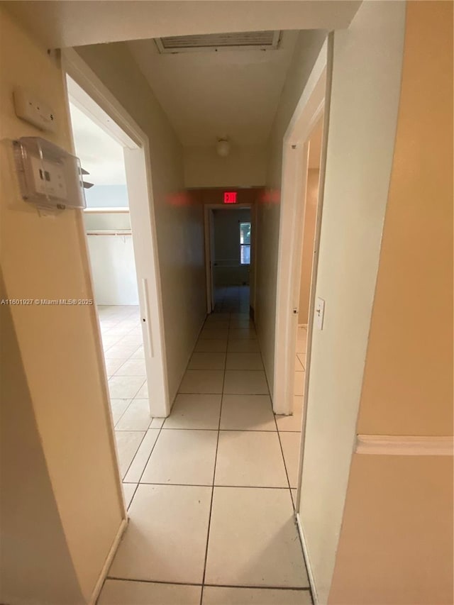 hall featuring visible vents and light tile patterned floors